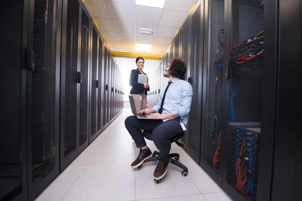 Technik kontroluje síťová zařízení v serverovně.