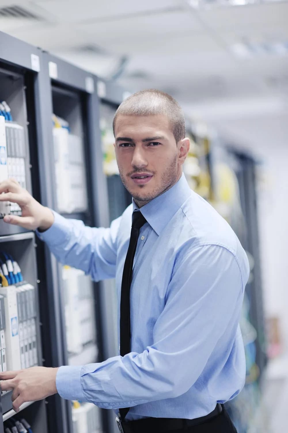 Technik kontroluje zařízení v serverové místnosti.