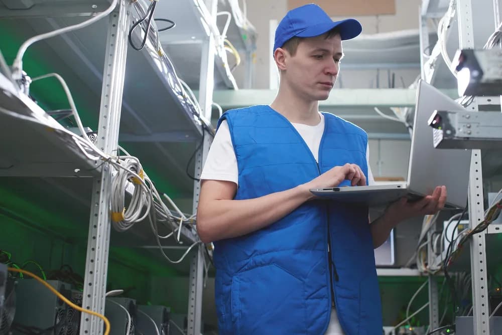 Technik instaluje optické kabely v rozvodné skříni.