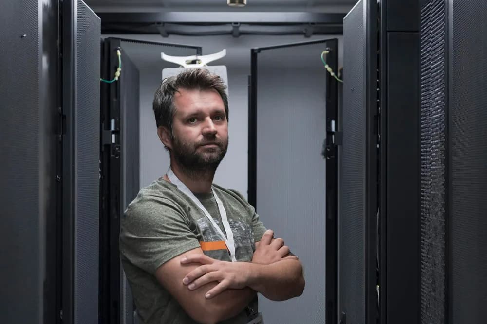 Technik kontroluje síťová zařízení ve firemní serverovně.