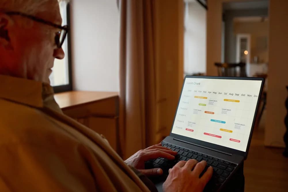 Na stole leží otevřený notebook vedle pracovních poznámek.