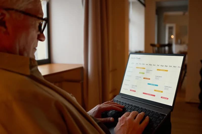 Na stole leží otevřený notebook vedle pracovních poznámek.