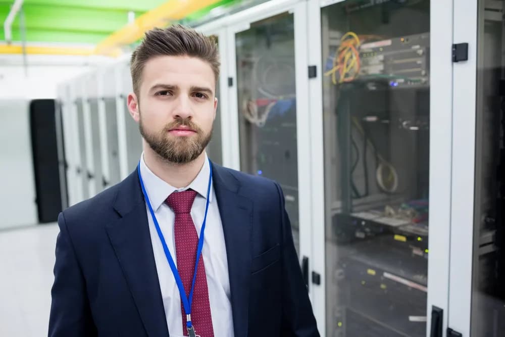 Správce kontroluje síťové zařízení v serverovně.