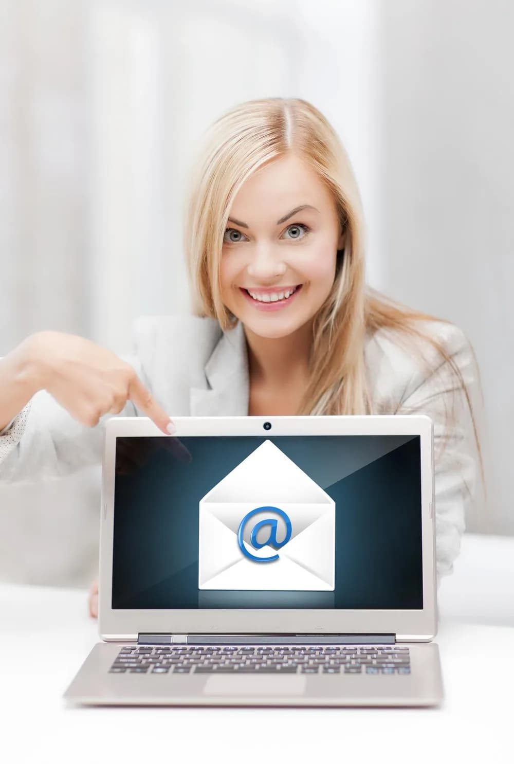 Zaměstnanec kontroluje e-mail na notebooku v kanceláři.