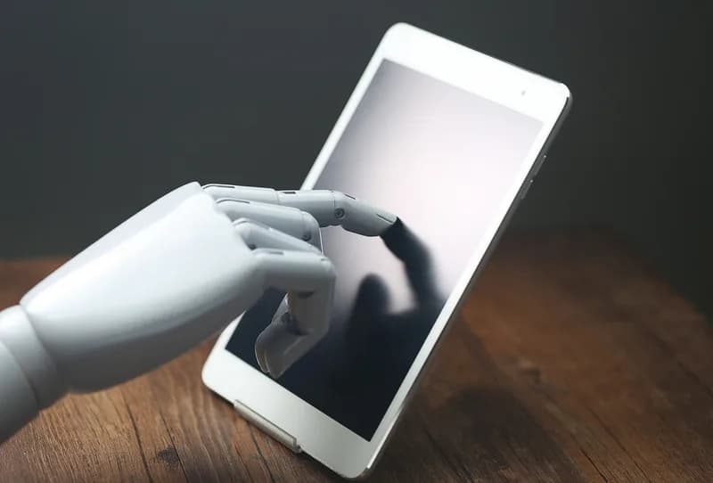 Robotická ruka ovládá dotykový tablet.